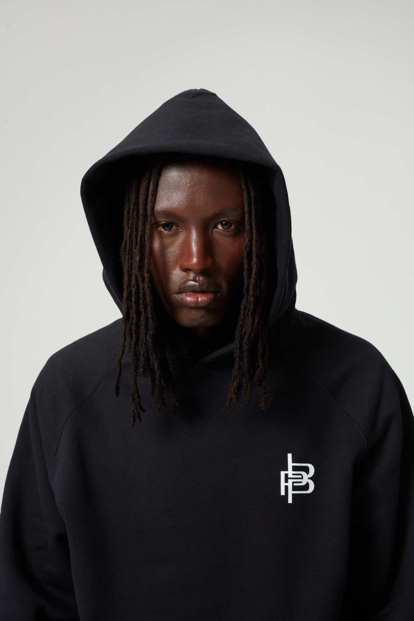 Porträt eines Models im schwarzen Piece-by-Piece-Hoodie mit aufgesetzter Kapuze