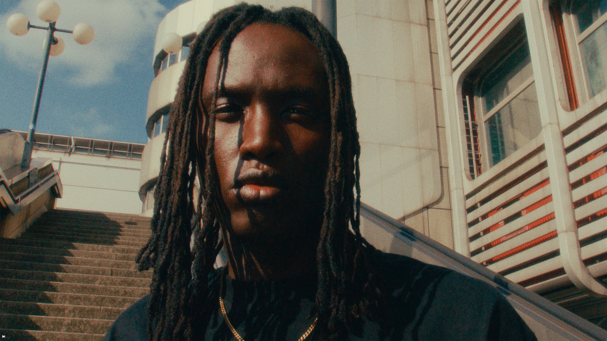 Model mit langen Locs vor einer Außentreppe – Piece by Piece Fashion-Produktion von 99views